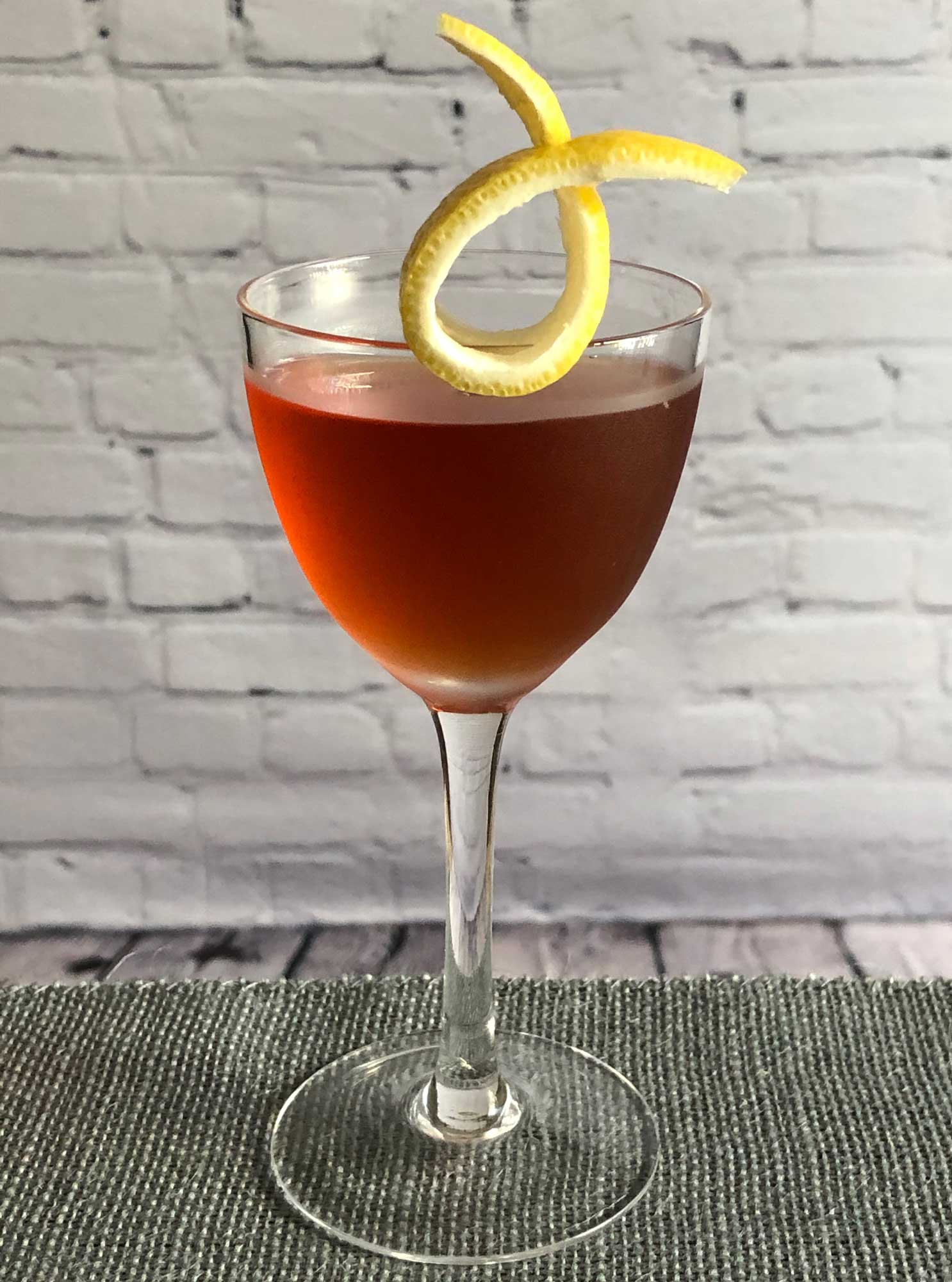 An example of the Moll Cocktail, the mixed drink (cocktail), by Savoy Cocktail Book, featuring Hayman’s Sloe Gin, Hayman’s London Dry Gin, Dolin Dry Vermouth de Chambéry, and orange bitters; photo by Lee Edwards