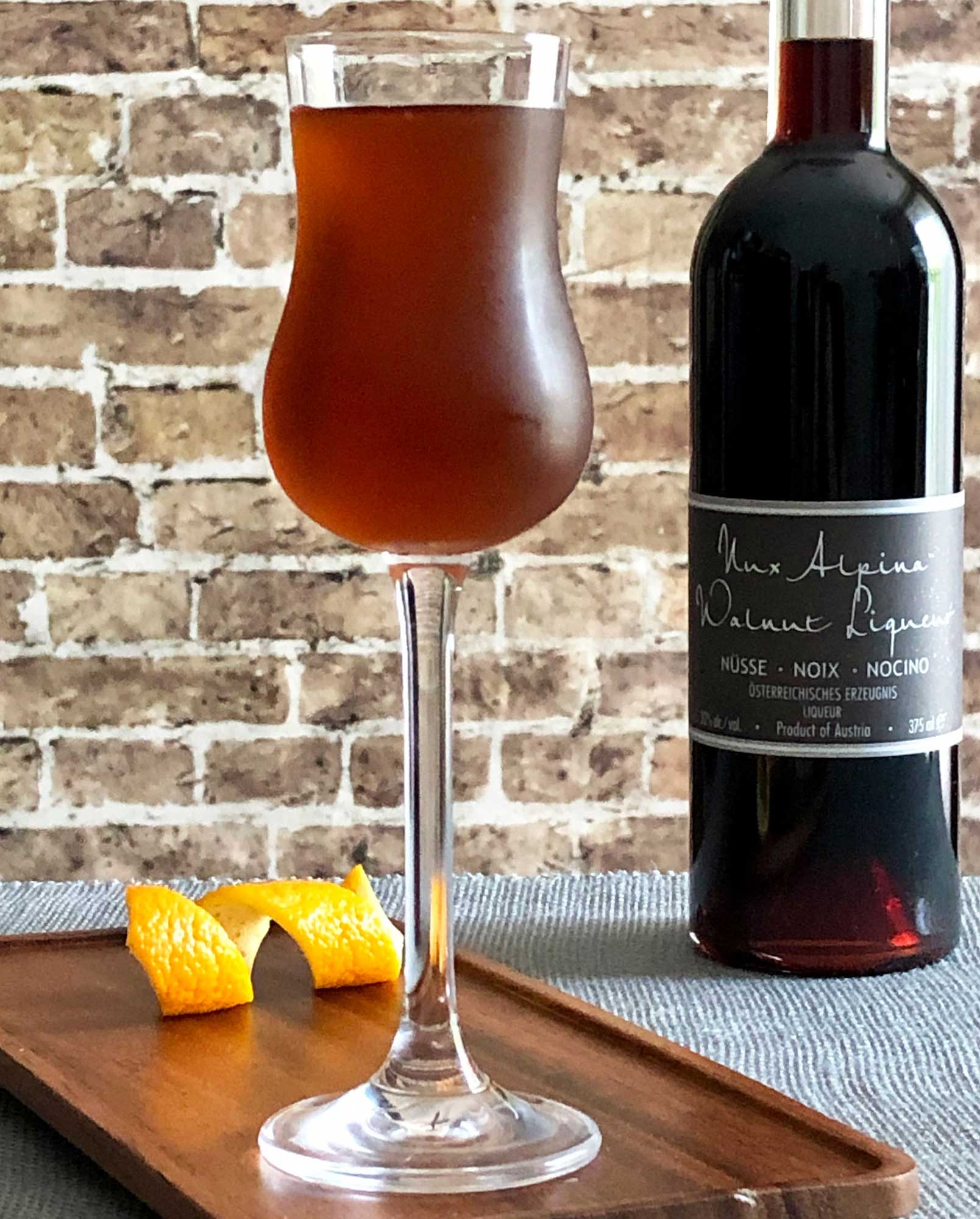 An example of the Mississauga Cocktail, the mixed drink (cocktail) featuring rye whiskey, Nux Alpina Walnut Liqueur, simple syrup, Angostura bitters, and orange bitters; photo by Lee Edwards
