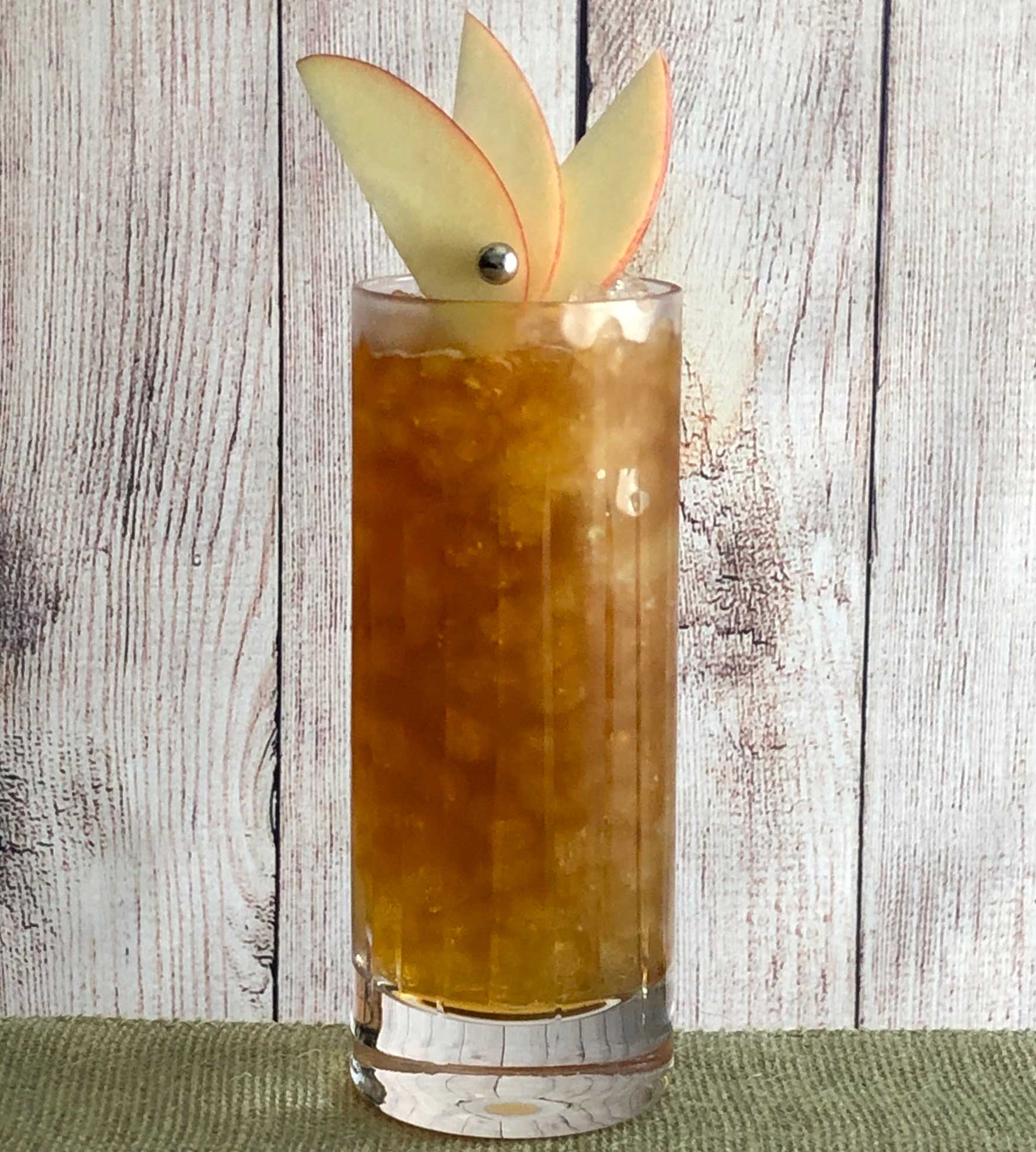 An example of the Orchard Fence Collins, the mixed drink (collins) featuring sweet cider, Purkhart Pear Williams Eau-de-Vie, Nux Alpina Walnut Liqueur, and lemon juice; photo by Lee Edwards