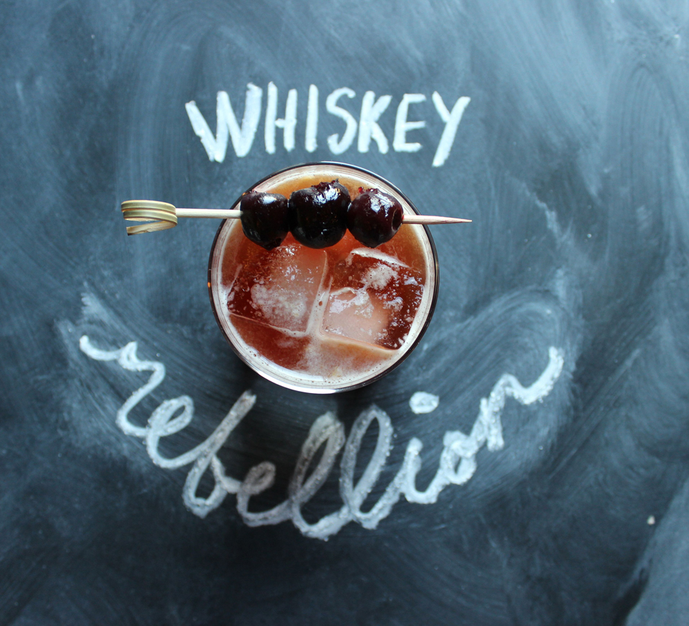 An example of the Whiskey Rebellion, the mixed drink (cocktail), by Brittany Bradley, South on Main, Little Rock, Arkansas, featuring Rothman & Winter Orchard Cherry Liqueur, rye whiskey, Cocchi Vermouth di Torino ‘Storico’, and orange juice; photo by Brittany Bradley