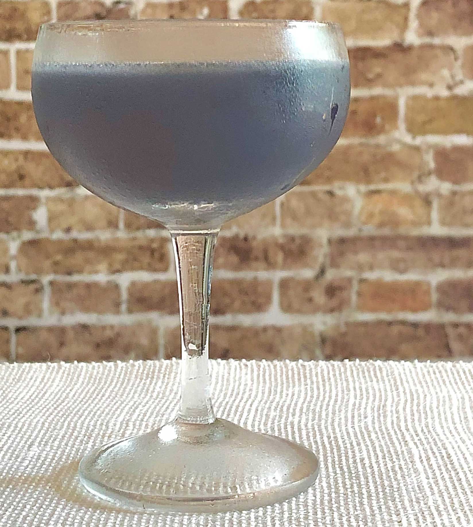 An example of the Blooey Blues, the mixed drink (cocktail), adapted from a drink from “Pioneers of Mixing at Elite Bars”, featuring light rum, Rothman & Winter Crème de Violette, lime juice, and Mas Peyre Rancio Sec “Le Démon de Midi”; photo by Lee Edwards