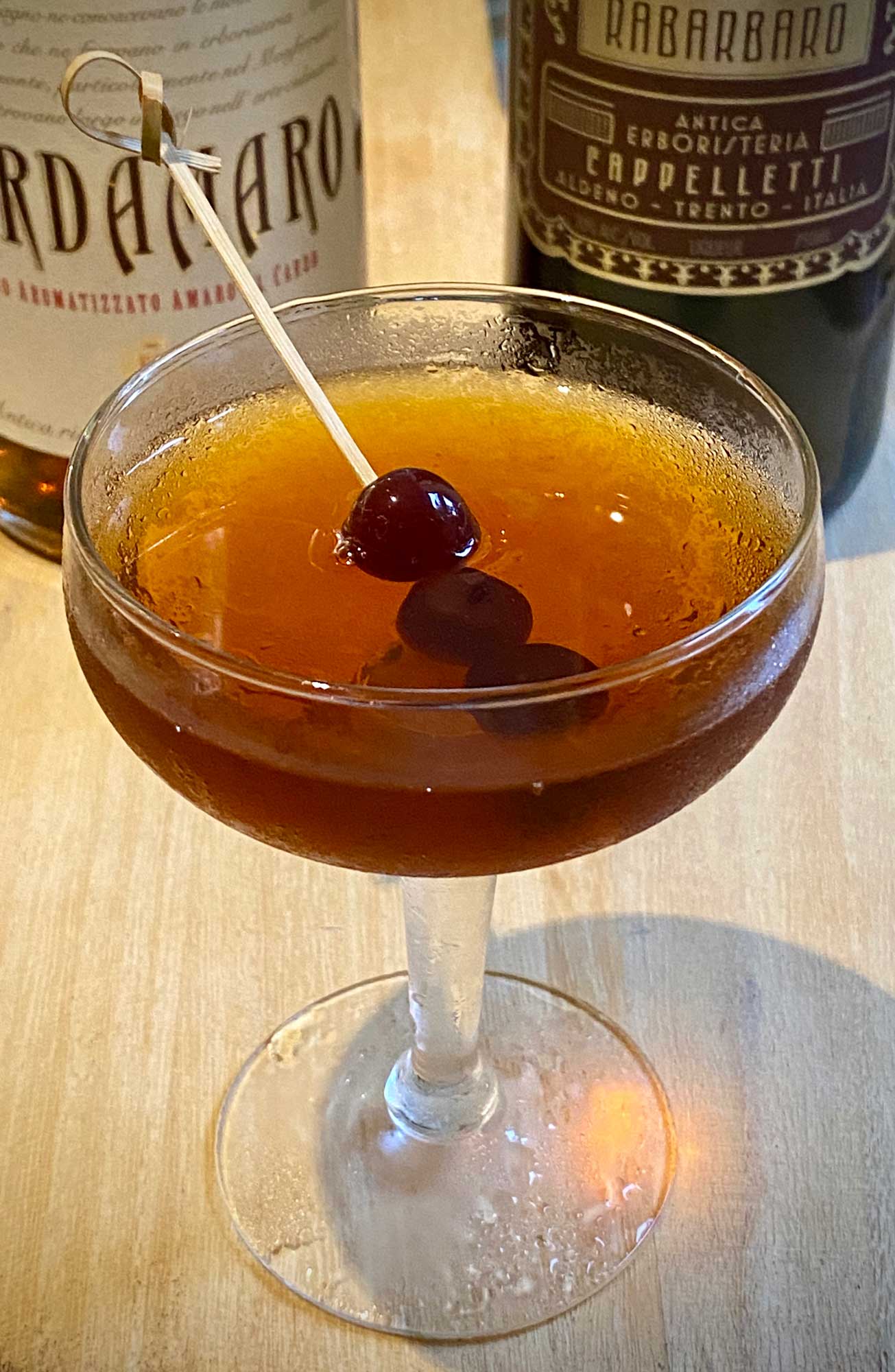 An example of the Amaro Manhattan, the mixed drink (cocktail) featuring bourbon whiskey, Cardamaro Vino Amaro, and Amaro Sfumato Rabarbaro; photo by Martin Doudoroff
